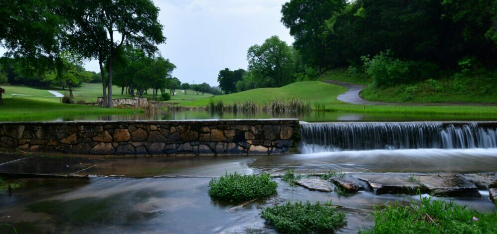 Gold course cart path crossing a small stream late in the evening