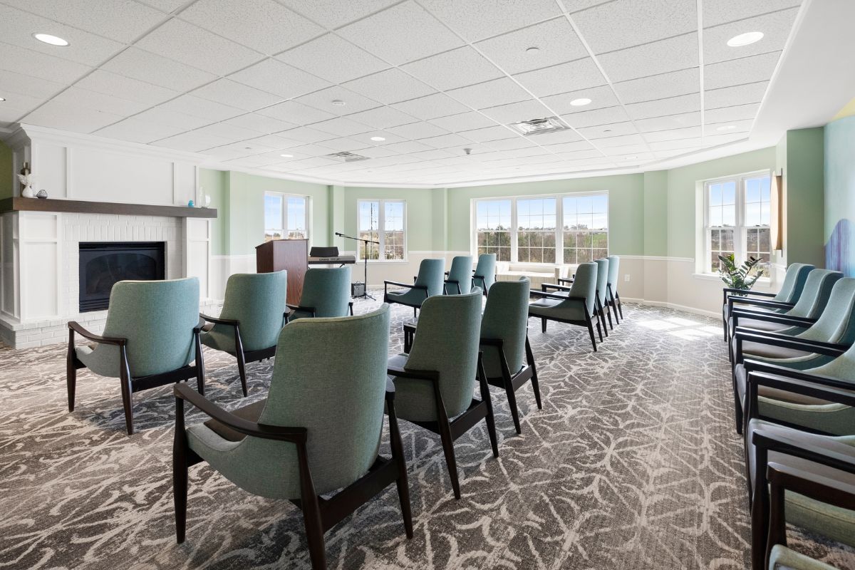 The chapel is a wide room surrounded by windows and filled with chairs and a podium at Arbour Square of Harleysville 55+ independent senior community Harleysville PA