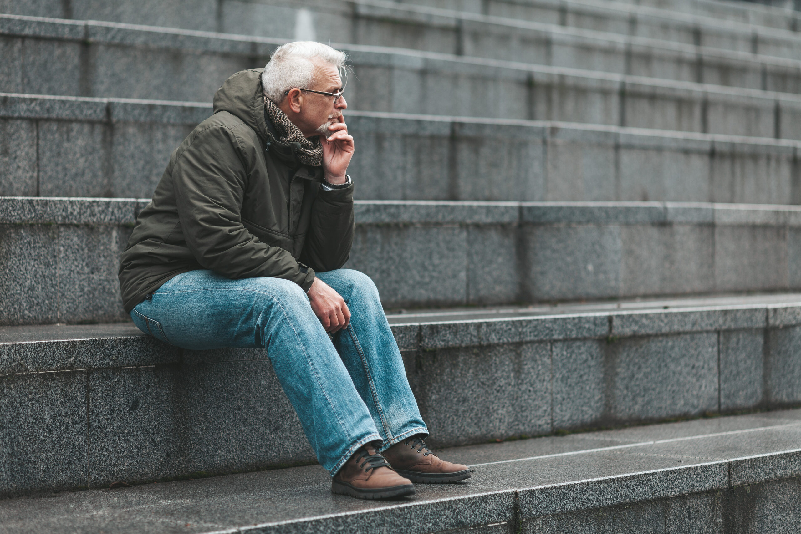 Depression-in-seniors-man-sitting-on-stairs-staring-out-true-connection-communities