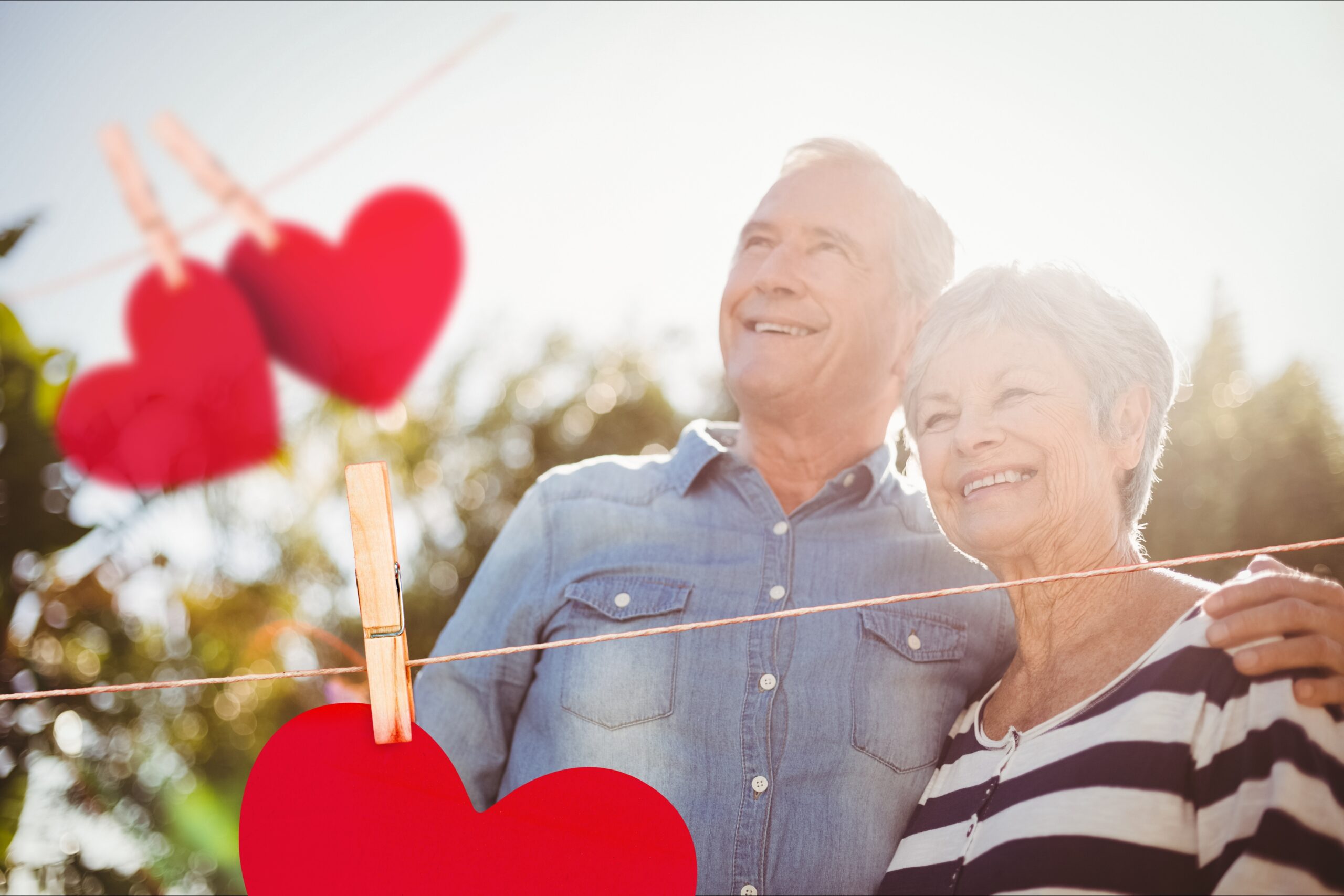 Red hanging hearts against senior couple in background