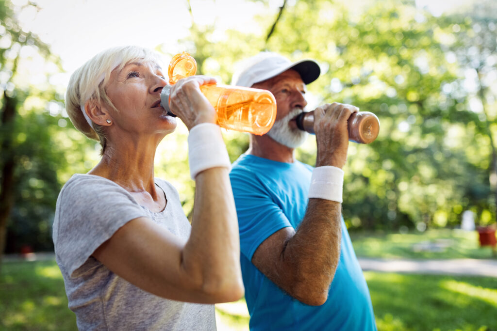 Senior couple staying hydrated after workout outdoor senior activities in summer staying hydrated