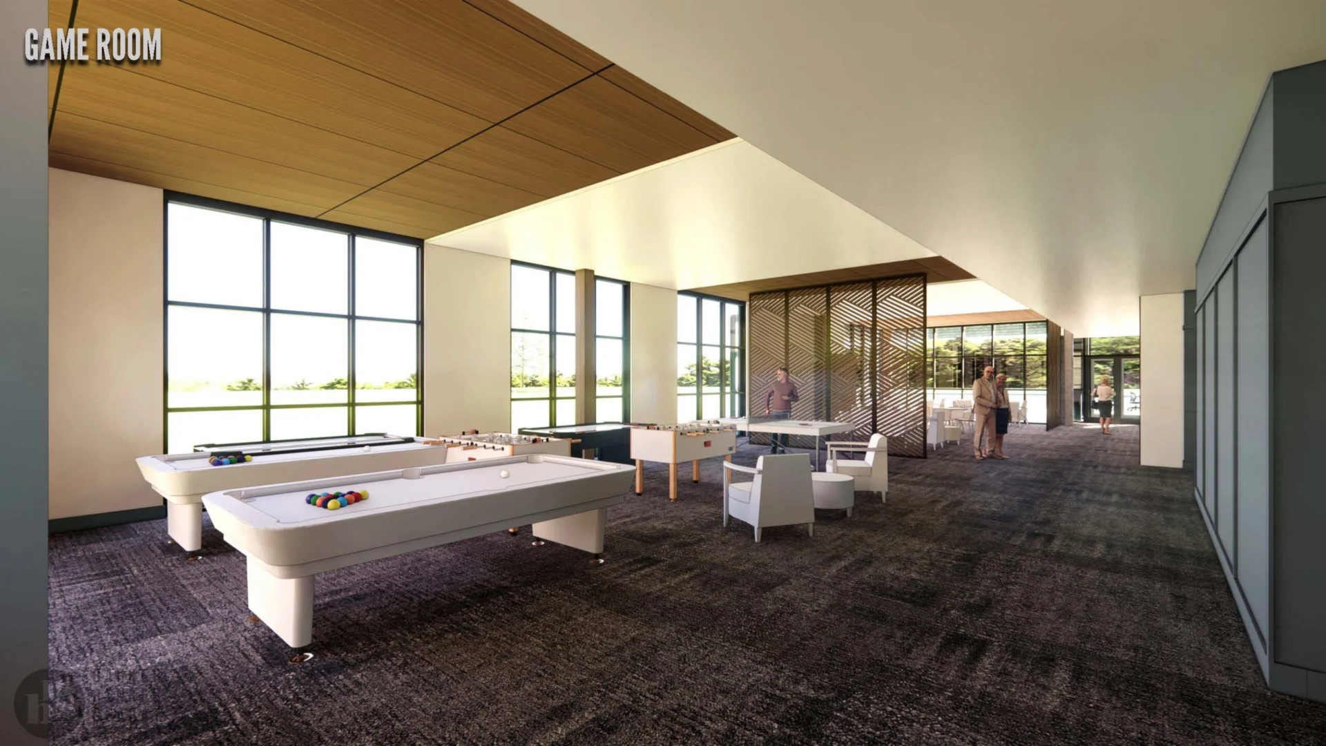 A modern game room in Hilliard, Ohio features pool and foosball tables, white chairs, a stylish divider, and abundant natural light—creating a spacious area ideal for luxury independent living.