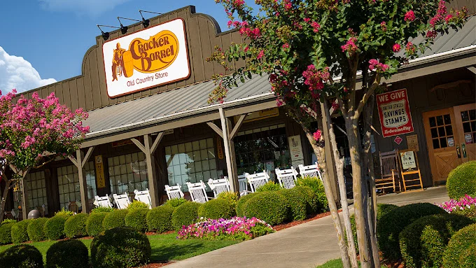 Restaurant building with a rustic porch, rocking chairs and blooming crepe myrtle trees