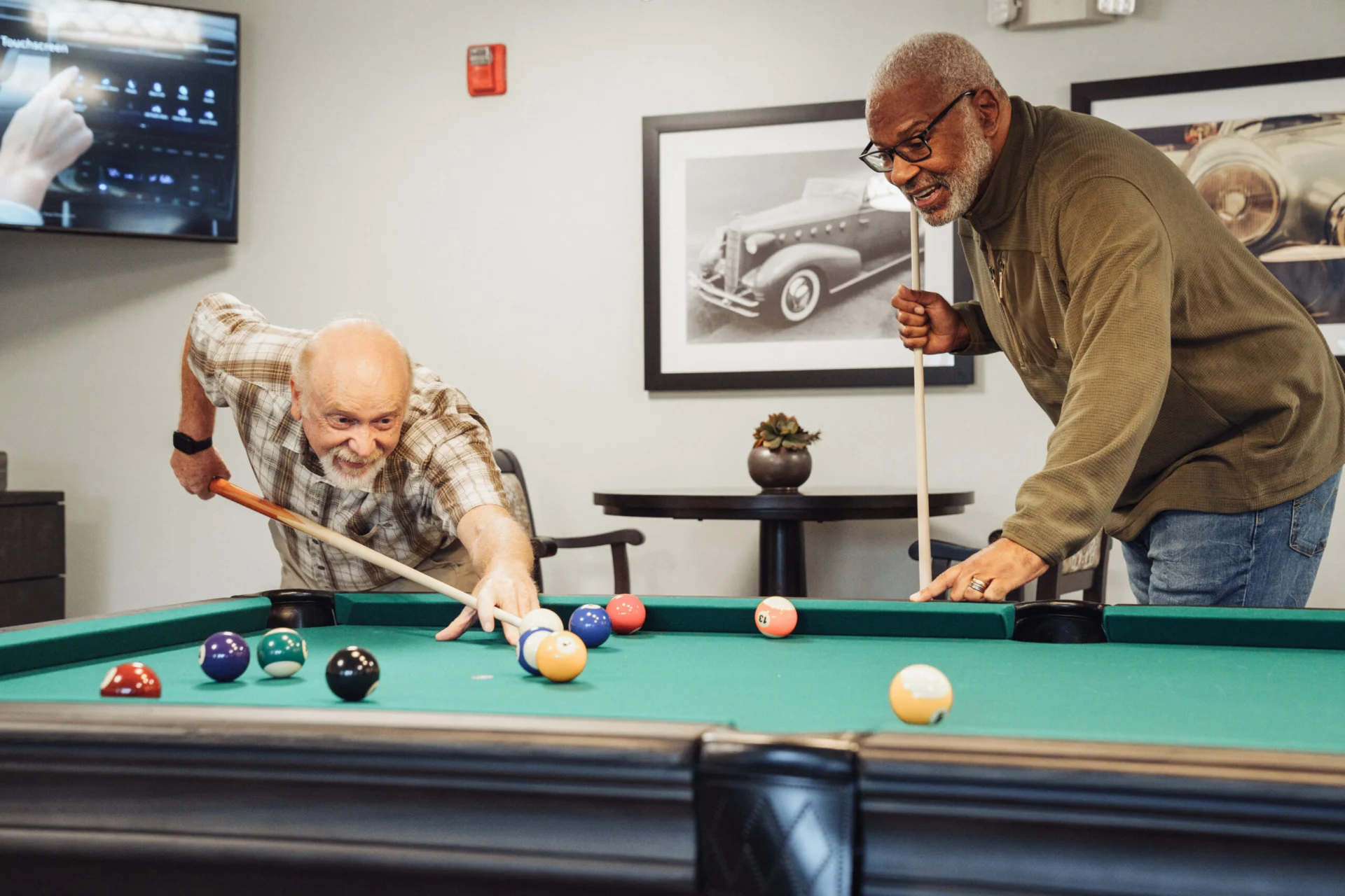 Two older men playing pool at a billiards table
