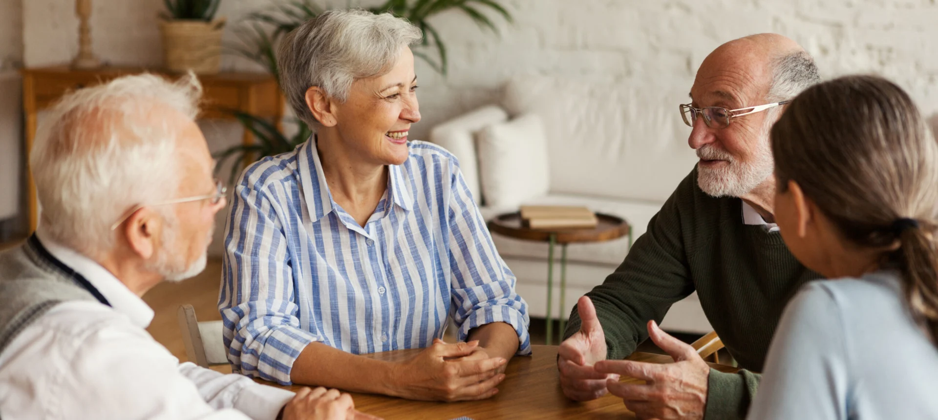 Older adults smiling and talking together around a table
