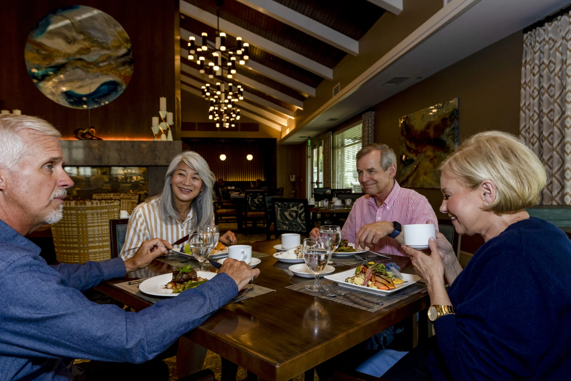 Group of older adults dining together at a table in a warmly lit restaurant