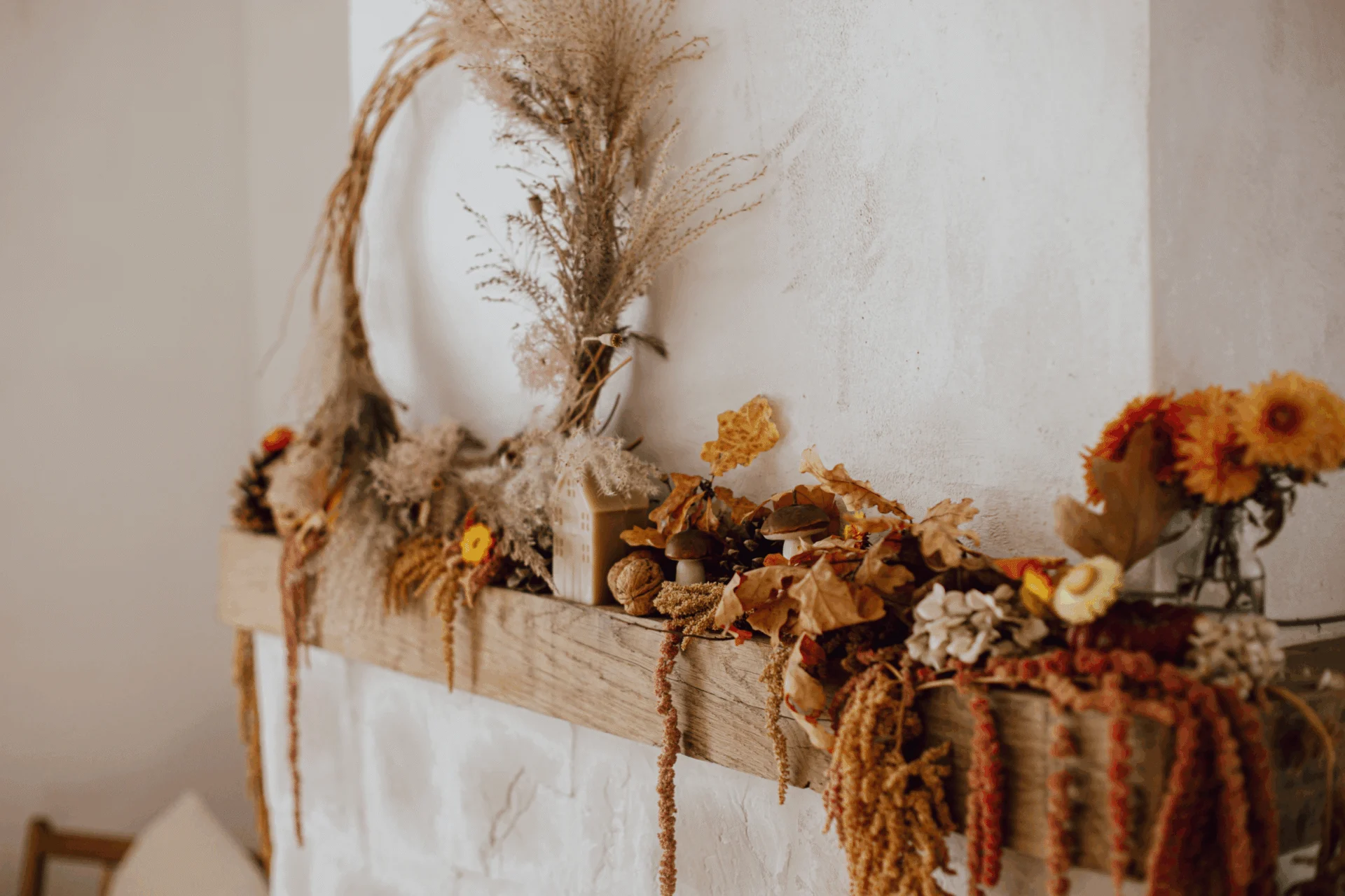 Mantel decorated with dried grasses, autumn flowers and a wreath