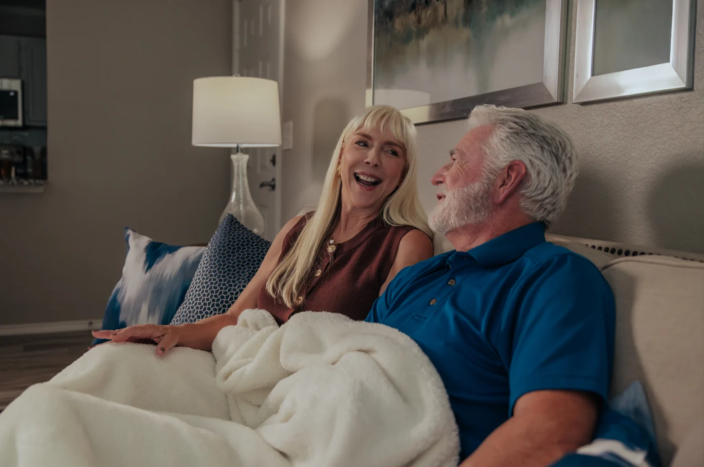 Older couple laughing and relaxing together under a blanket