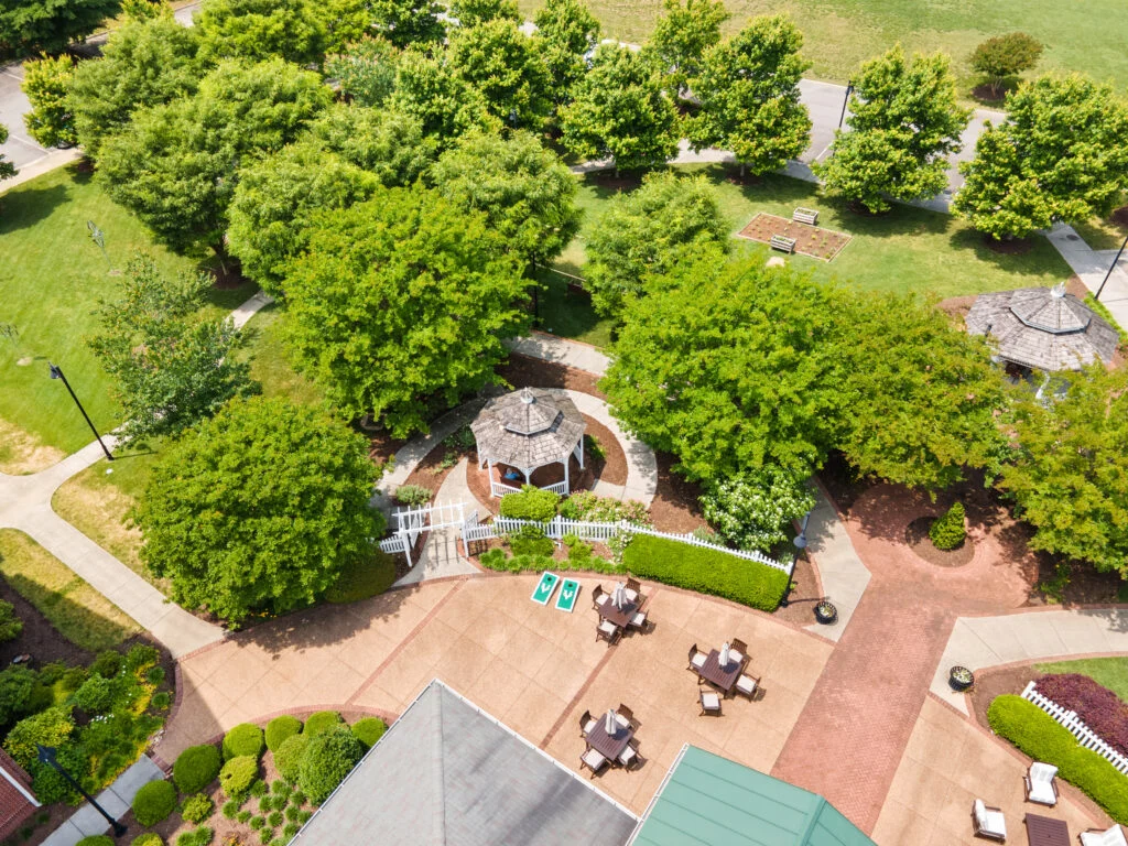 Aerial view of a courtyard with mature trees, a gazebo and a paved patio seating area