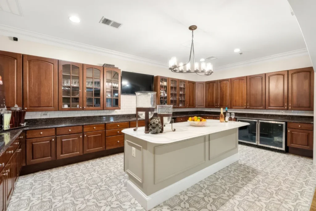 Large kitchen with wooden cabinets, a gray island and a chandelier