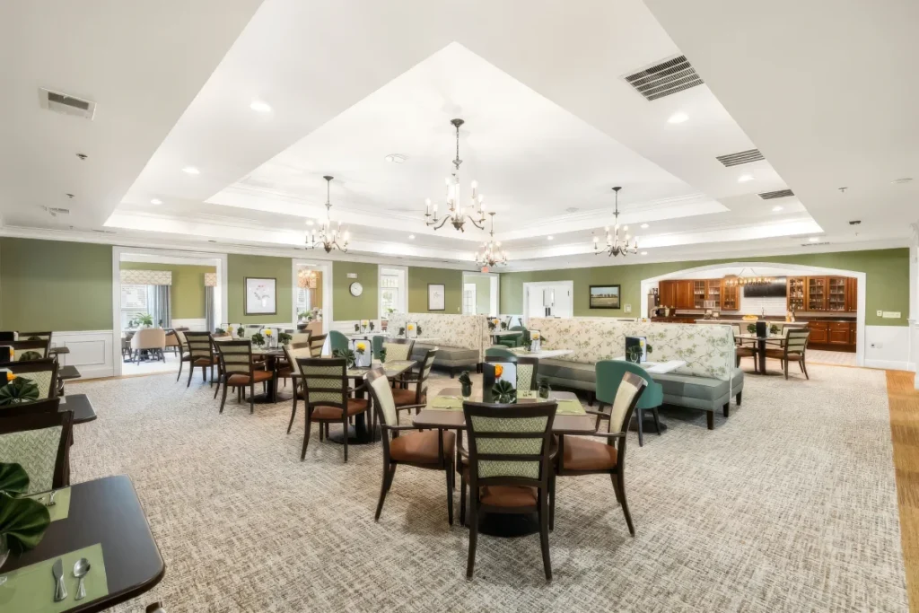 Large dining room with tables and chairs, chandeliers and a tray ceiling