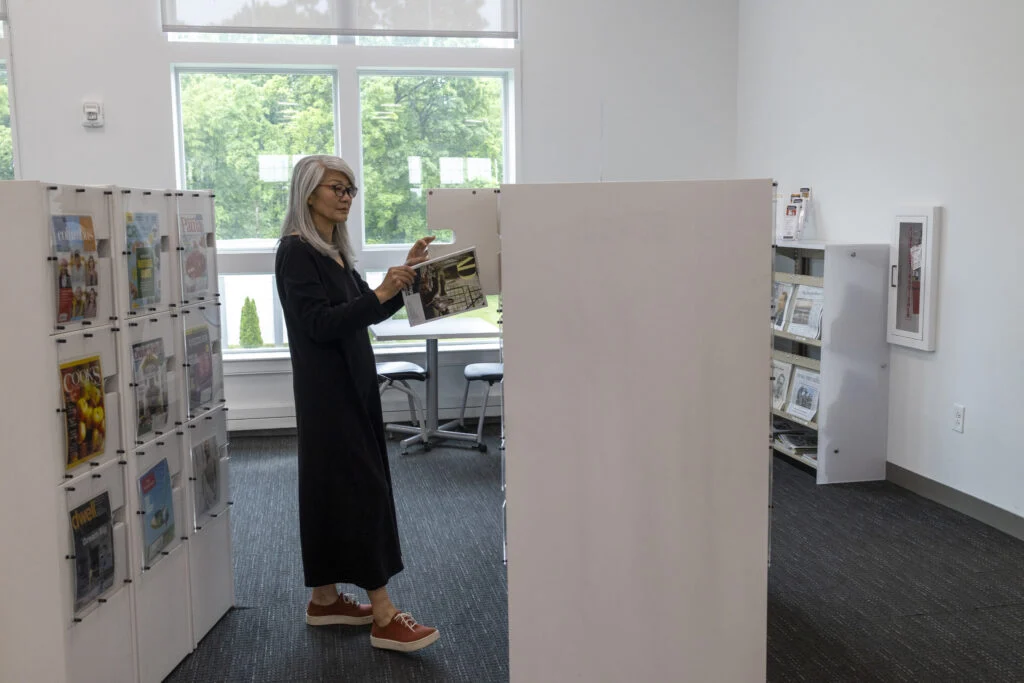 Woman looking at magazines on a display rack in a bright library