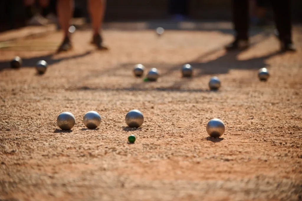 Petanque boules and target ball on the court during a game