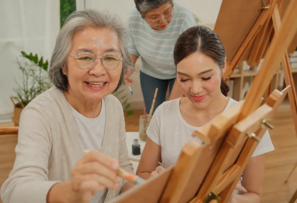 Caregiver helping a senior resident paint