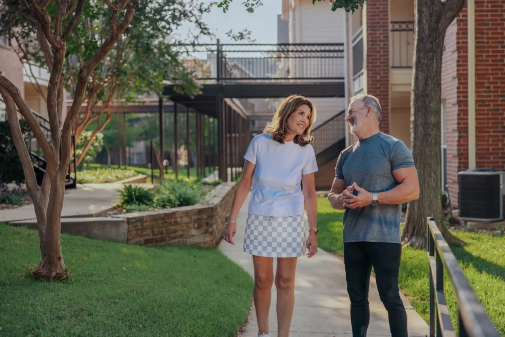 The Oaks at Plano residents walking on a path outside the apartments