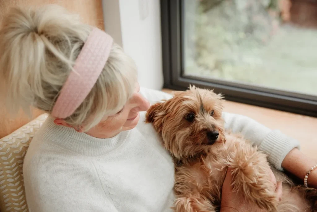 Senior woman relaxing in a chair with her small dog on her lap