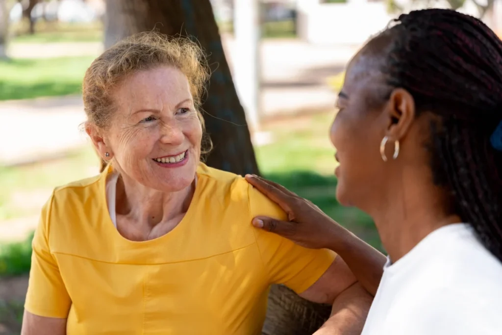 Senior women friends sharing a caring conversation outdoors