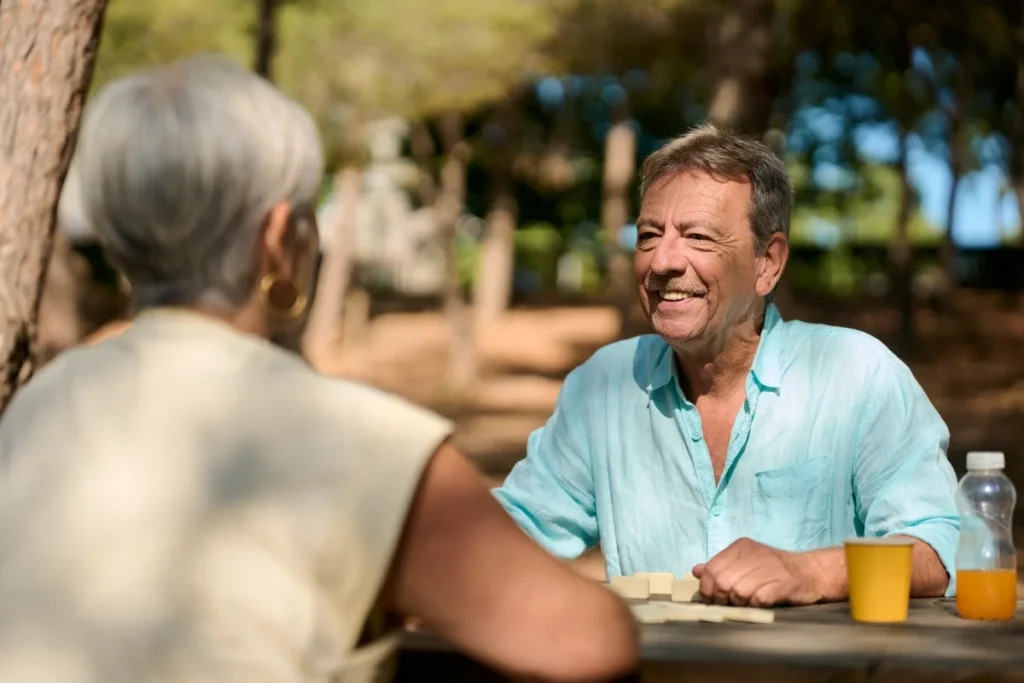 Senior couple playing dominoes together outdoors in summer