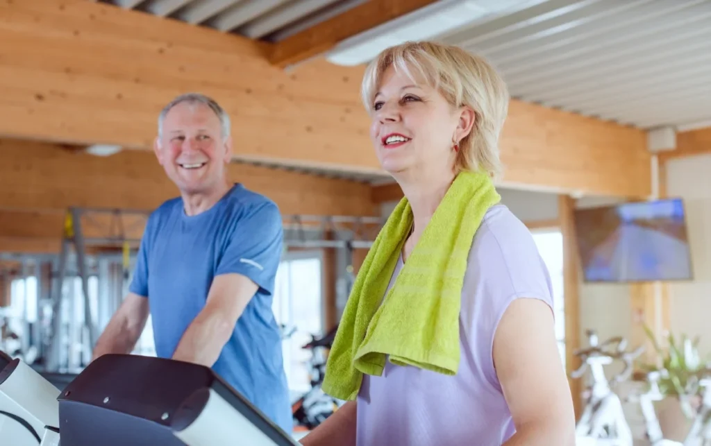 Senior couple exercising together on treadmills at the gym