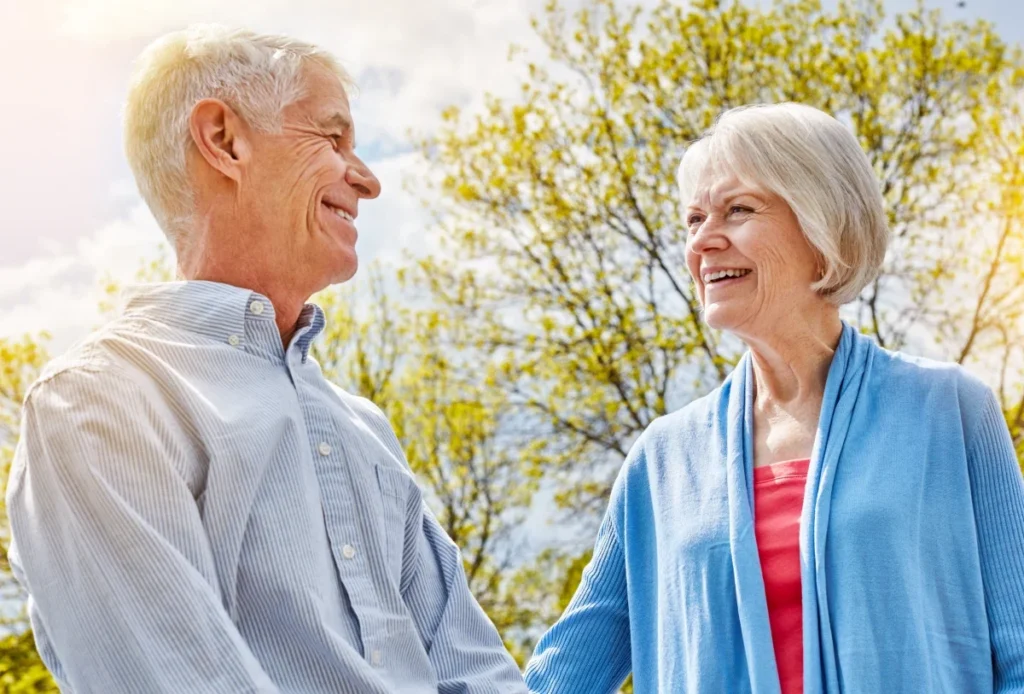Senior couple walking and laughing together in a park