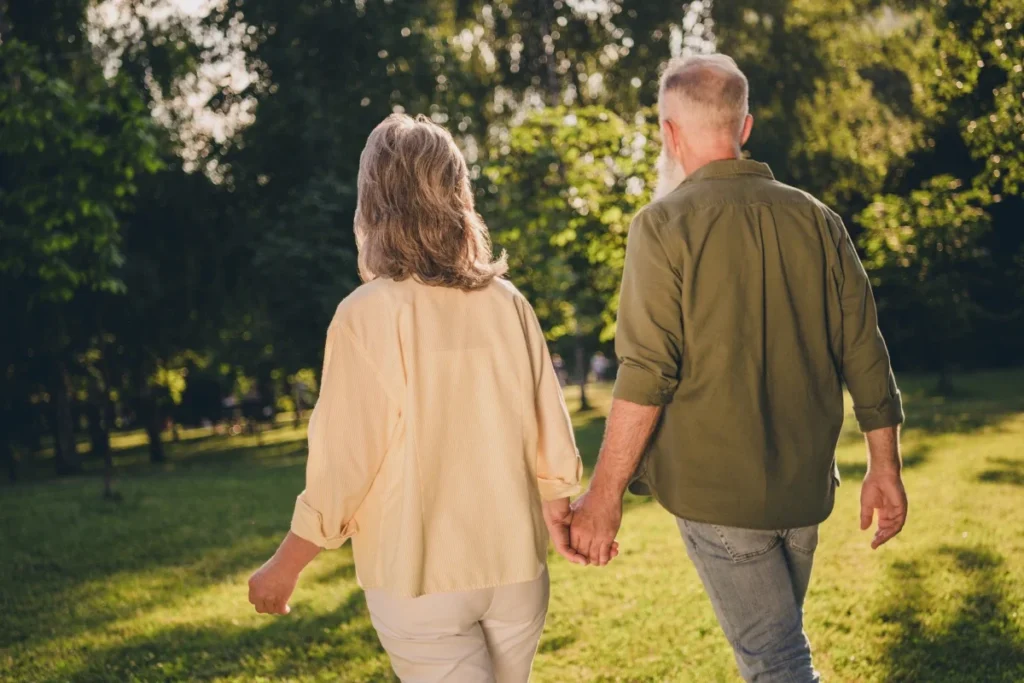 Senior couple walking arm in arm through a park