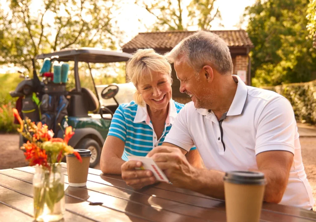 Senior couple having coffee and reviewing their golf scorecard together