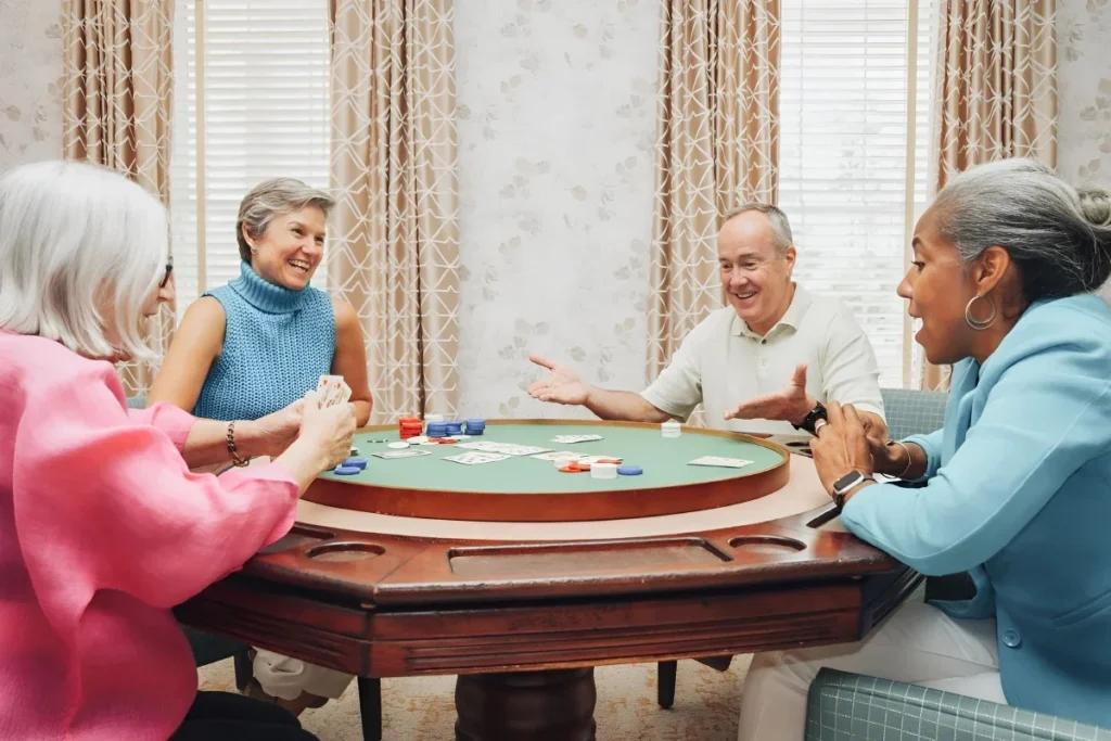 Seniors playing cards around a round game table with poker chips