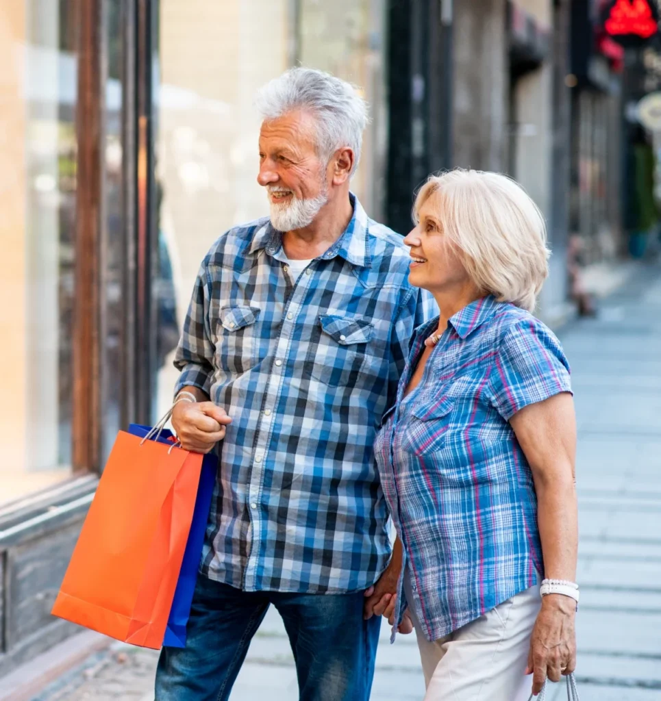 Senior couple shopping and looking at a store window together