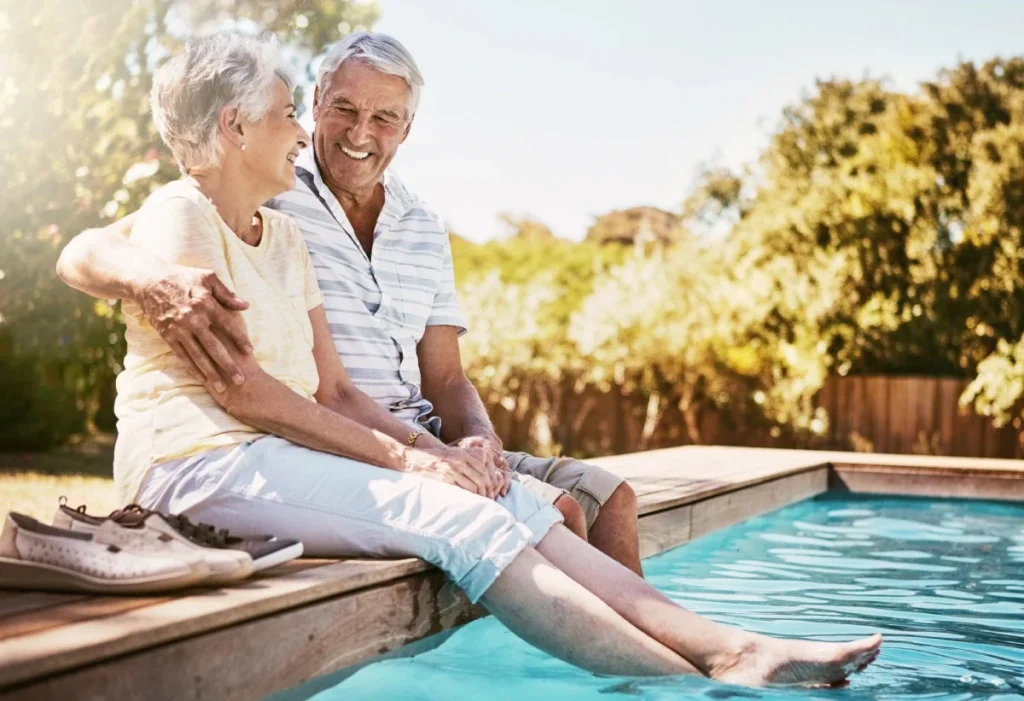 Senior couple relaxing together by a swimming pool