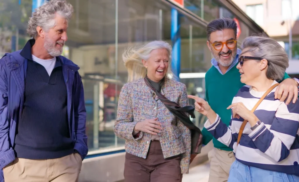 Senior friends laughing together while walking outdoors