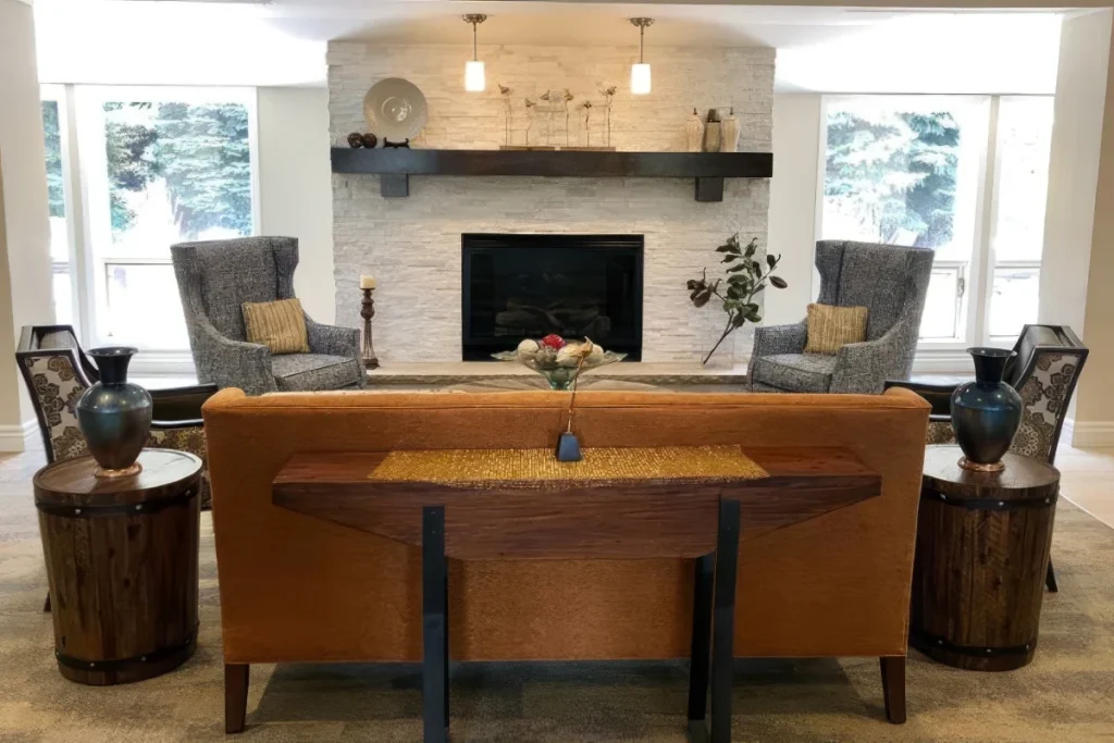 Living room with a leather sofa, two gray armchairs, a fireplace and large windows