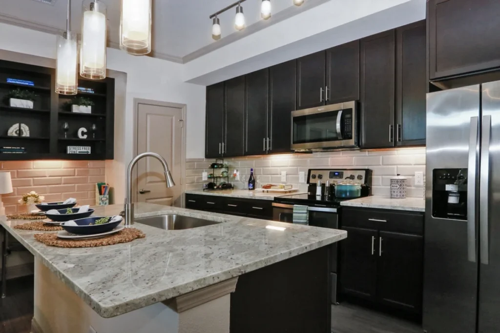 Kitchen with dark cabinets, a granite island and stainless steel appliances