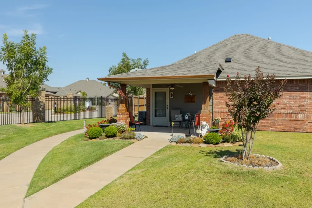 Brick single-story home with a fenced yard and a curving walkway through the lawn
