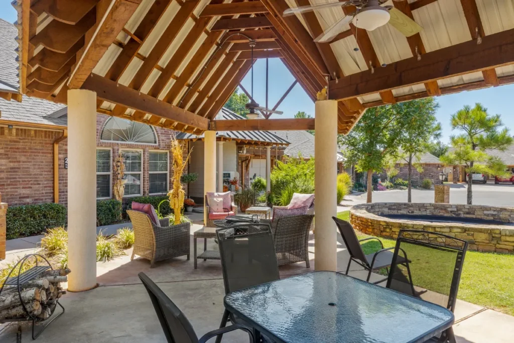 Covered outdoor pavilion with a timber roof, patio seating and a stone water feature