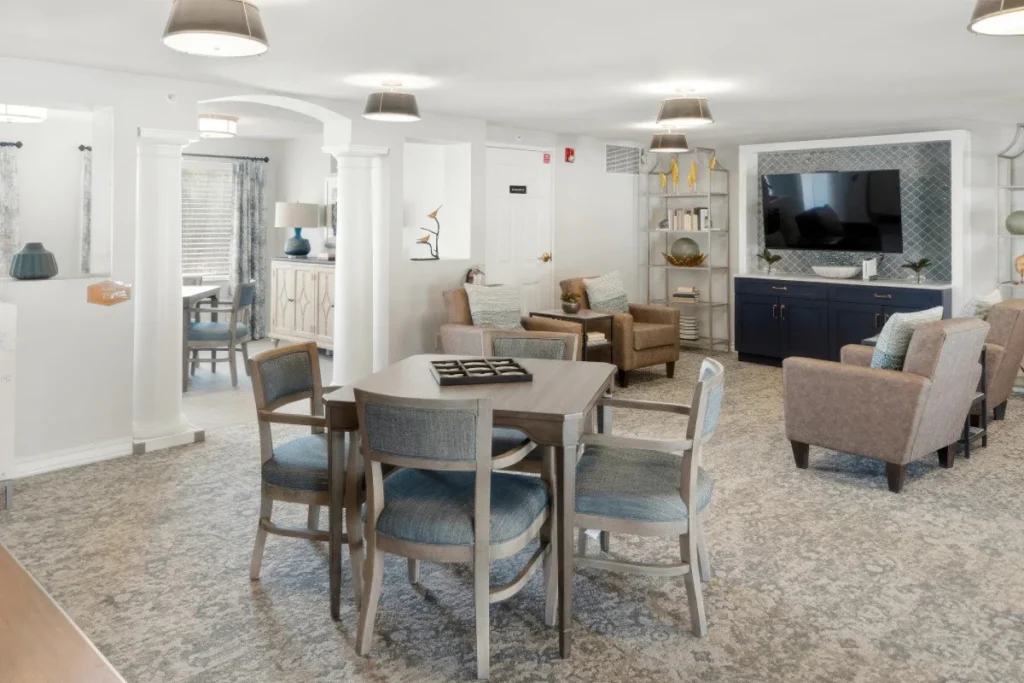 Lounge with a dining table, armchairs and a wall-mounted TV on a media console