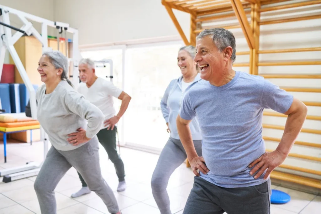Older adults doing standing exercises together in a bright gym