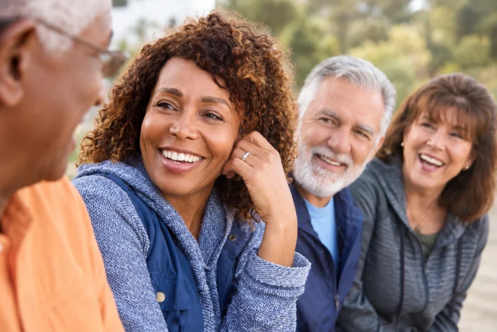 Group of smiling older adults laughing and talking together outdoors