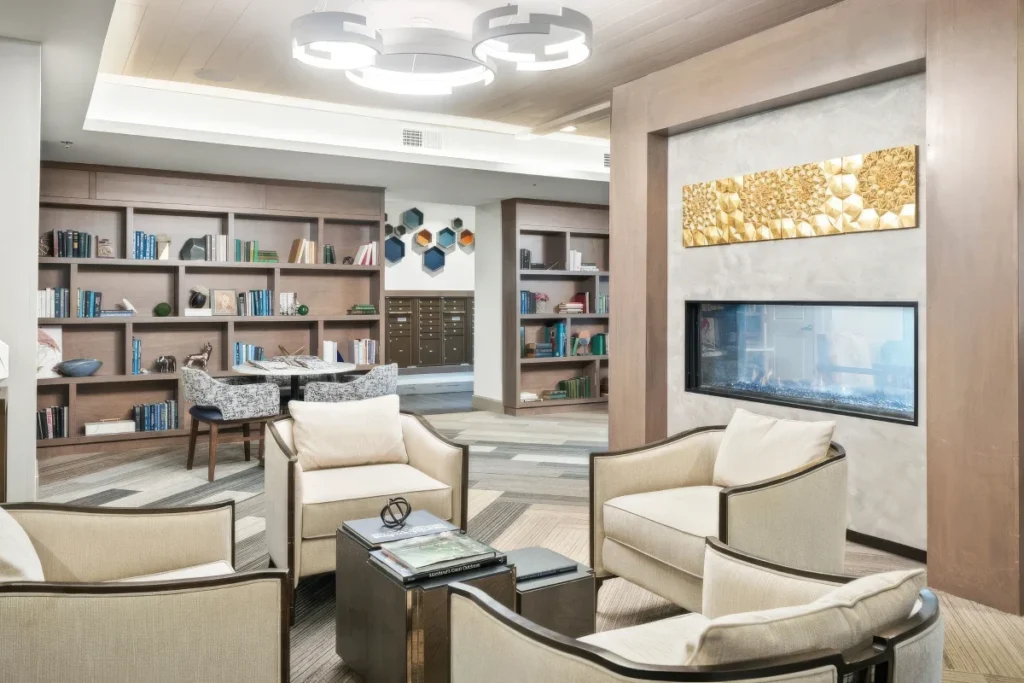 Lounge with cushioned chairs, built-in bookshelves and a linear fireplace