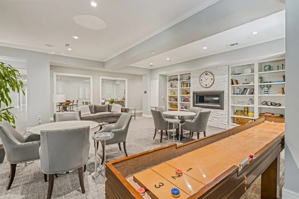 Lounge with a shuffleboard table, tables, armchairs and built-in shelves