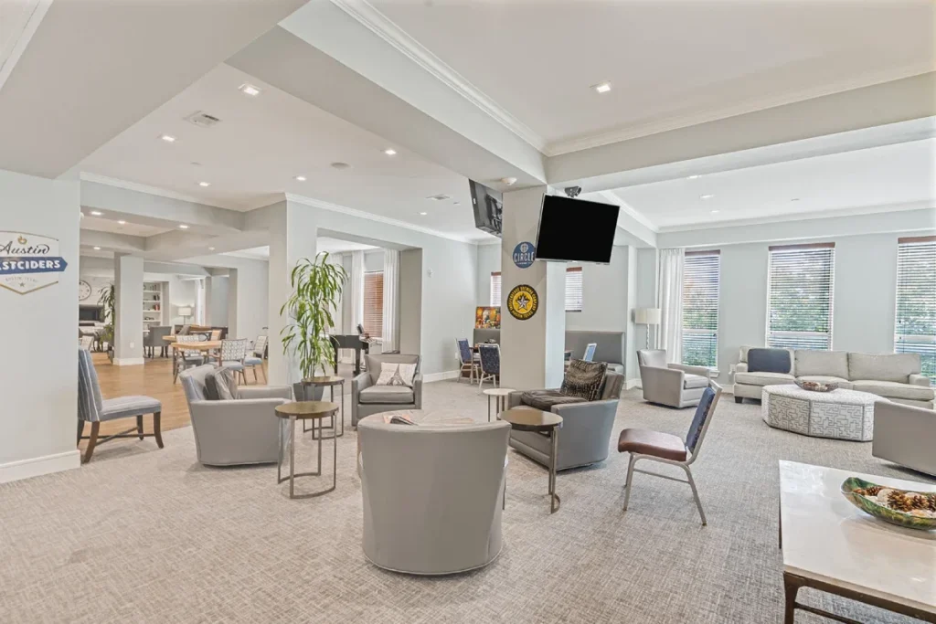Large lounge with seating groups, TVs and tall windows