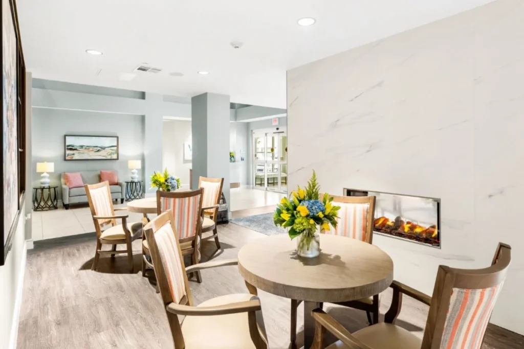 Living and dining area with a round table with yellow flowers, and a fireplace