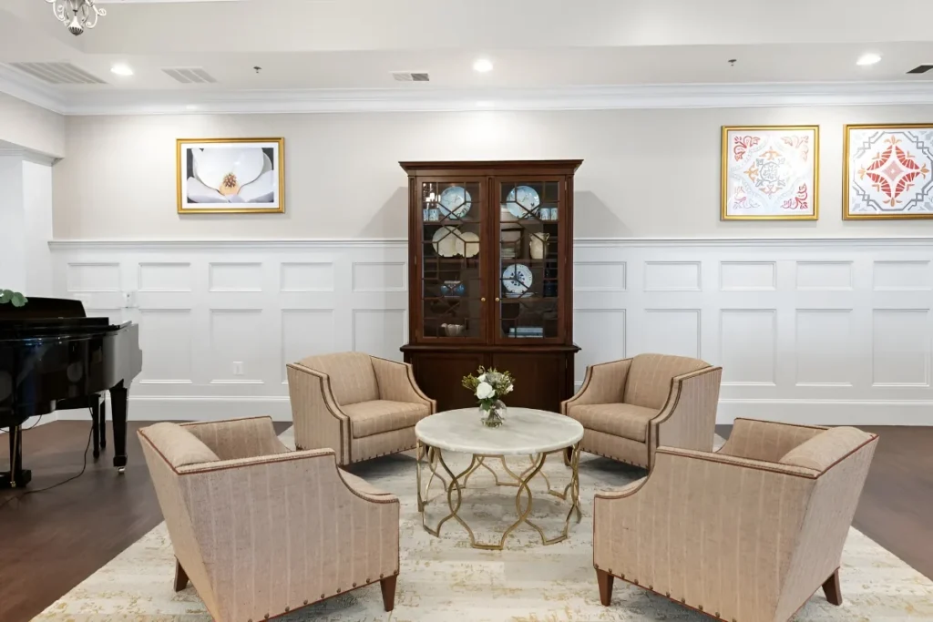 Music lounge with a grand piano, armchairs, a china cabinet and framed art
