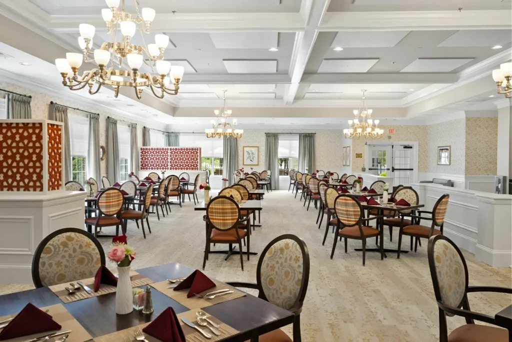 Elegant dining room with chandeliers, set tables and cushioned chairs