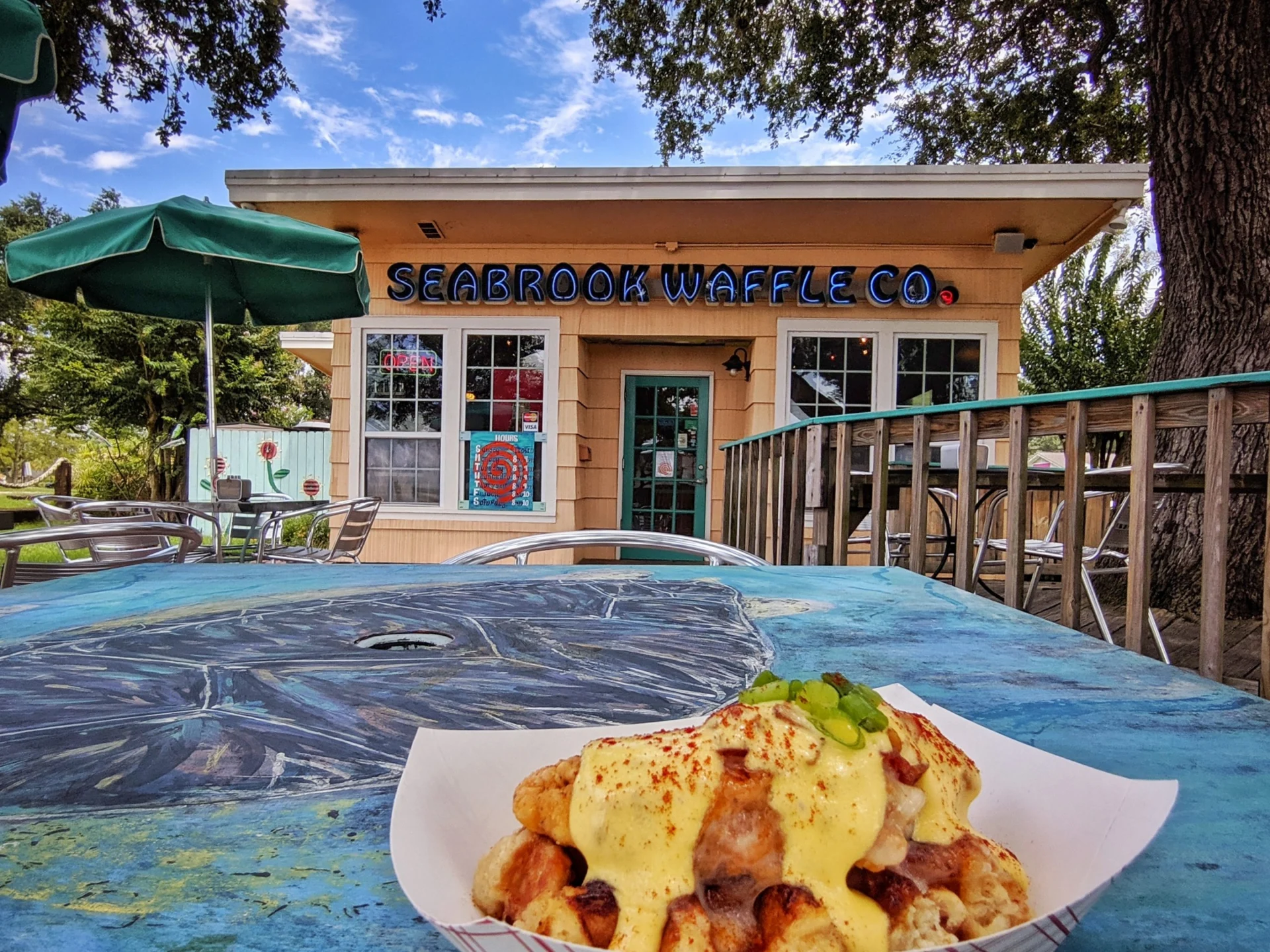 Plate of breakfast food on an outdoor patio table at a local waffle restaurant