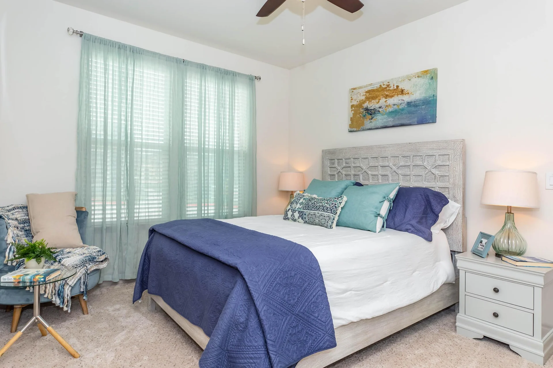 Bedroom with a made bed, nightstands, lamp and window