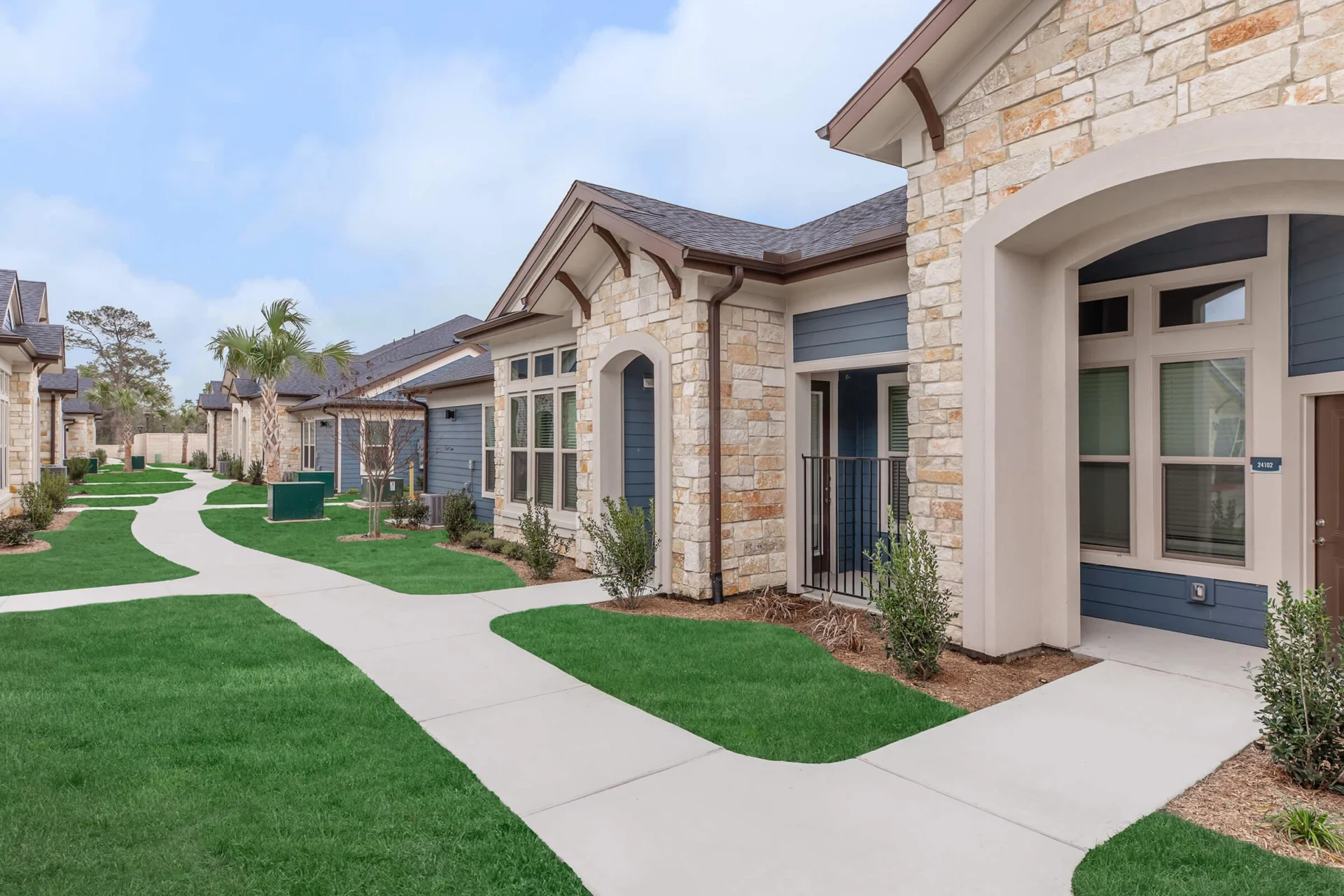 Cottage homes with stone accents along a landscaped sidewalk