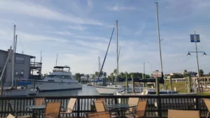 Boats docked at a marina with sailboat masts behind a railing