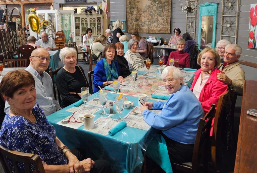 Large group of seniors dining together at a decorated table in a restaurant