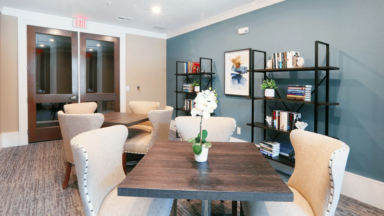 Dining table set for a meal beside a shelving unit