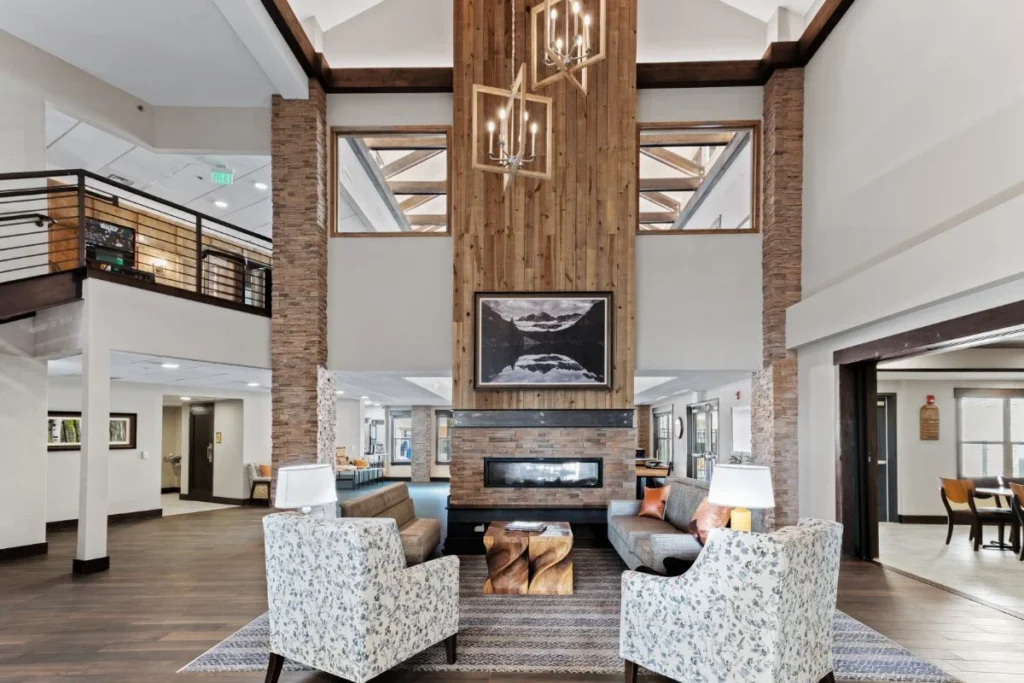 Two-story lobby lounge with a central fireplace and wood-trimmed pillars